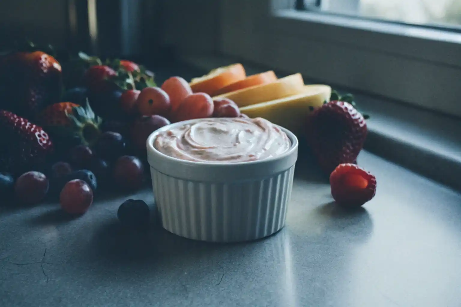 A creamy fruit dip with fresh strawberries and apple slices